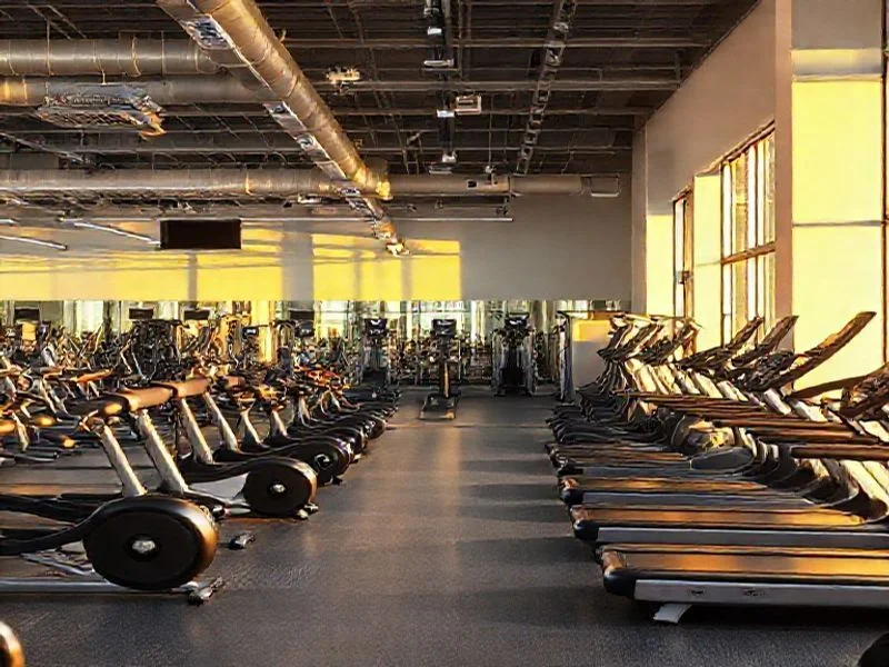 A dynamic, slightly angled shot of a next-generation resistance training machine. It's sleek, matte black with polished chrome accents, and a singular, glowing electric blue data interface integrated seamlessly into its structure. The machine is in an implied state of motion, perhaps a blurred background or subtle motion lines around its moving parts, conveying energy and sophisticated functionality without showing a person.